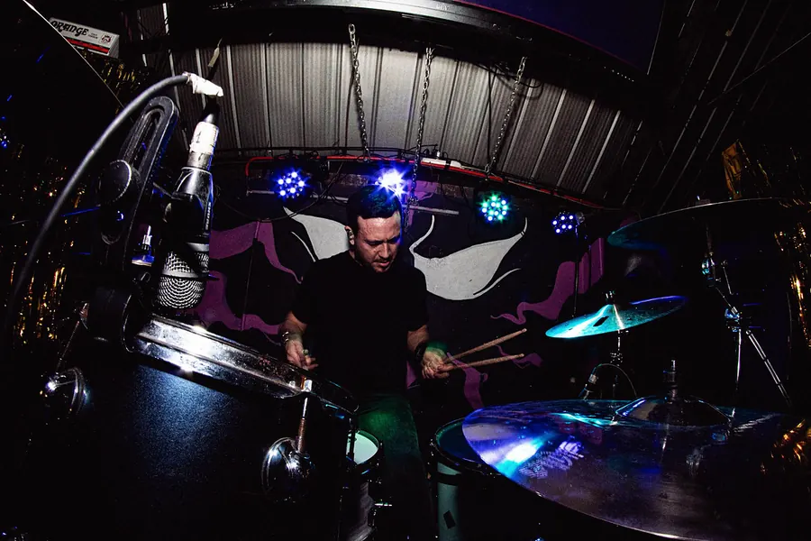 Baterista mirando la caja, luces azules